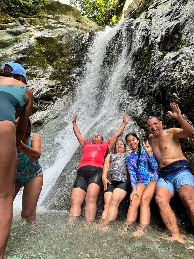 Familia y equipo compartiendo bajo una cascada
