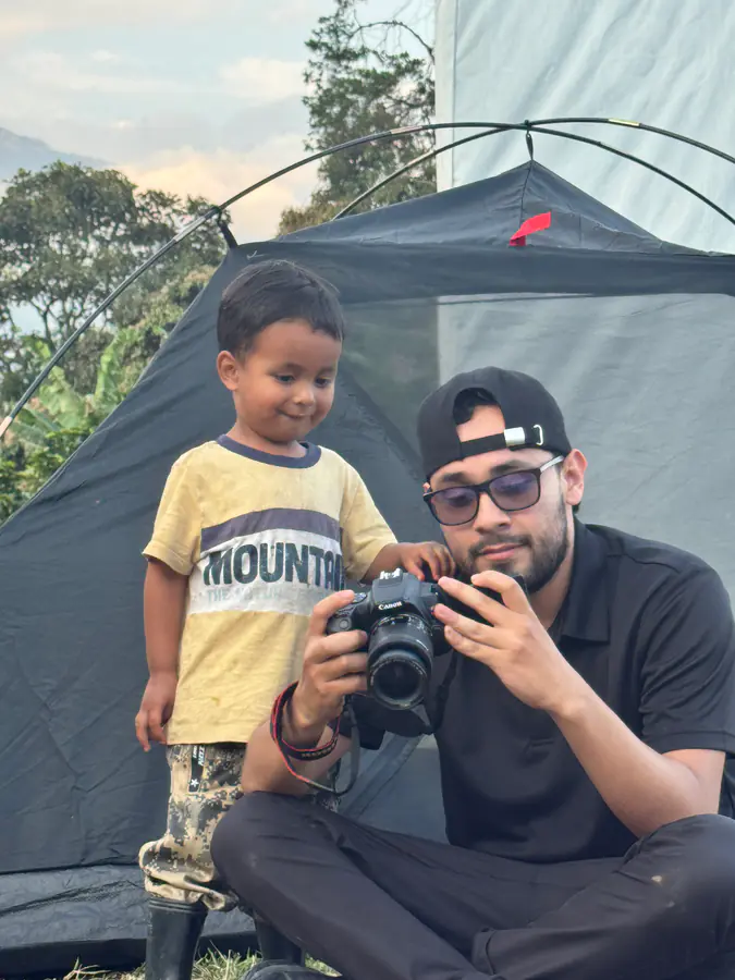 Momento tierno entre un adulto y un niño revisando fotos de la caminata
